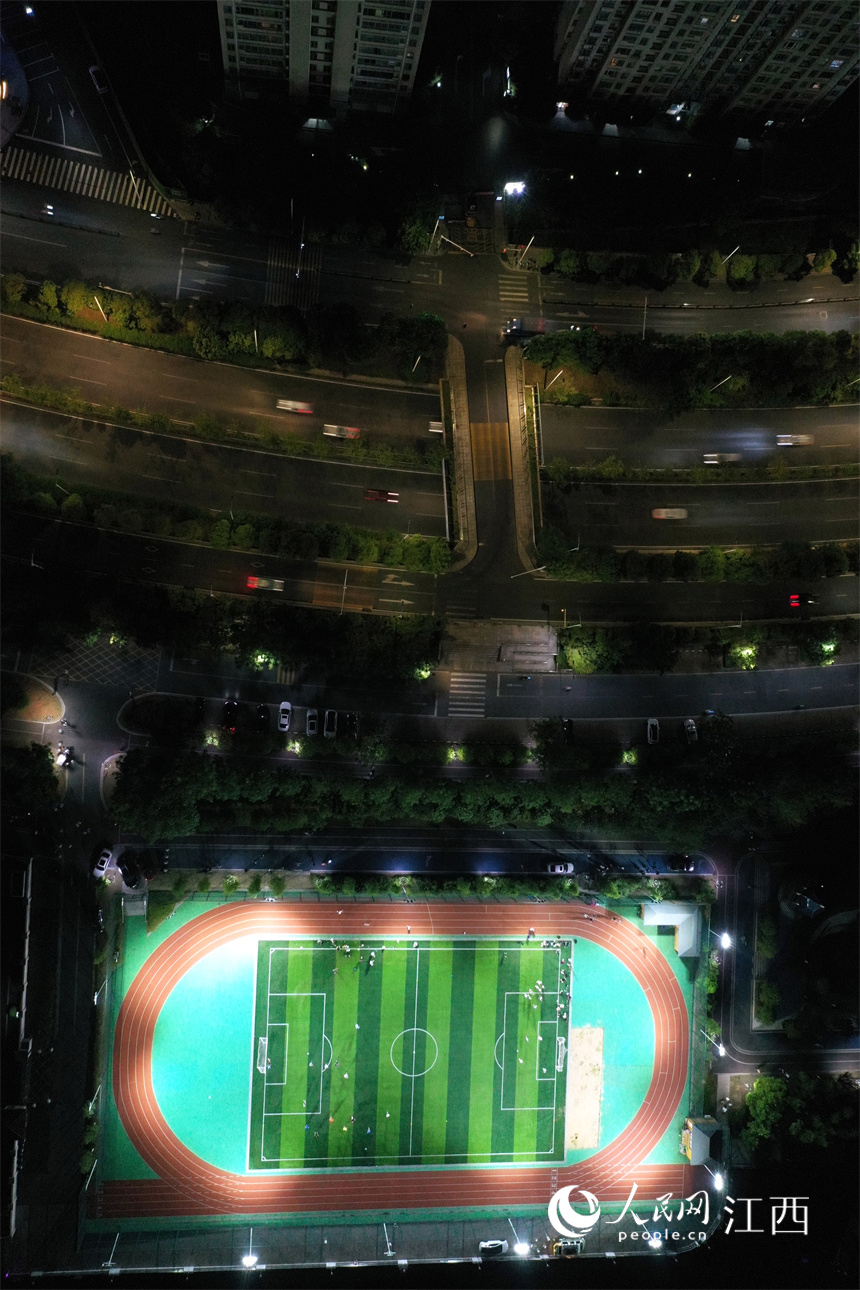 贛江旁的球場上燈火通明，市民正在球場馳騁比拼、揮灑汗水。 人民網 時雨攝