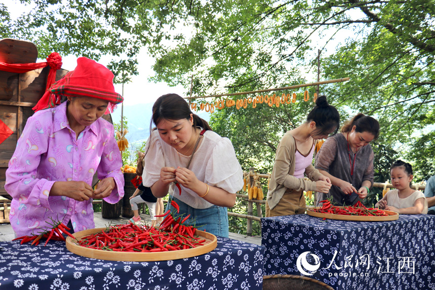 農趣運動會上，游客們正在進行串辣椒比賽。人民網 李途遙攝