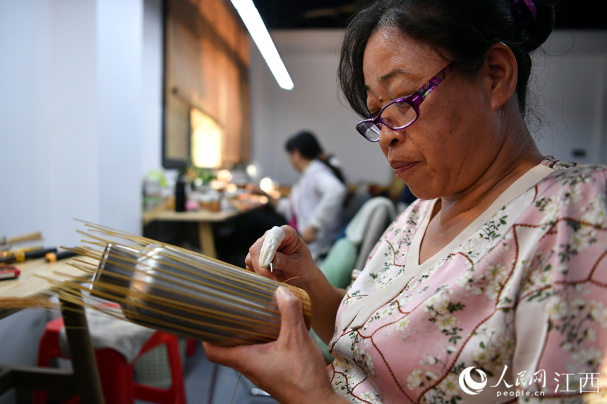 村民們在竹藝中心制作竹編產品，這些精美的產品既美觀又實用且銷路廣。 人民網 時雨攝