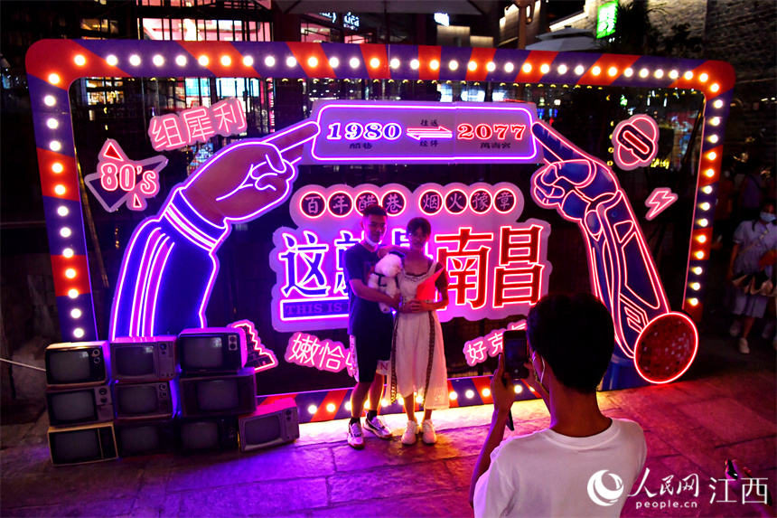 游客們在夜市的“打卡點”拍照。 人民網 時雨攝