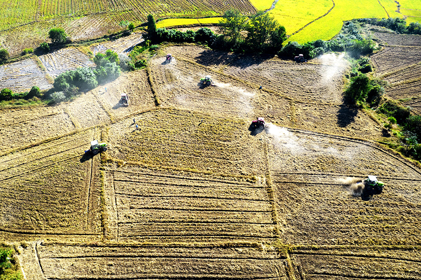 農戶駕駛著旋耕機在田里進行翻耕作業。吳志貴攝