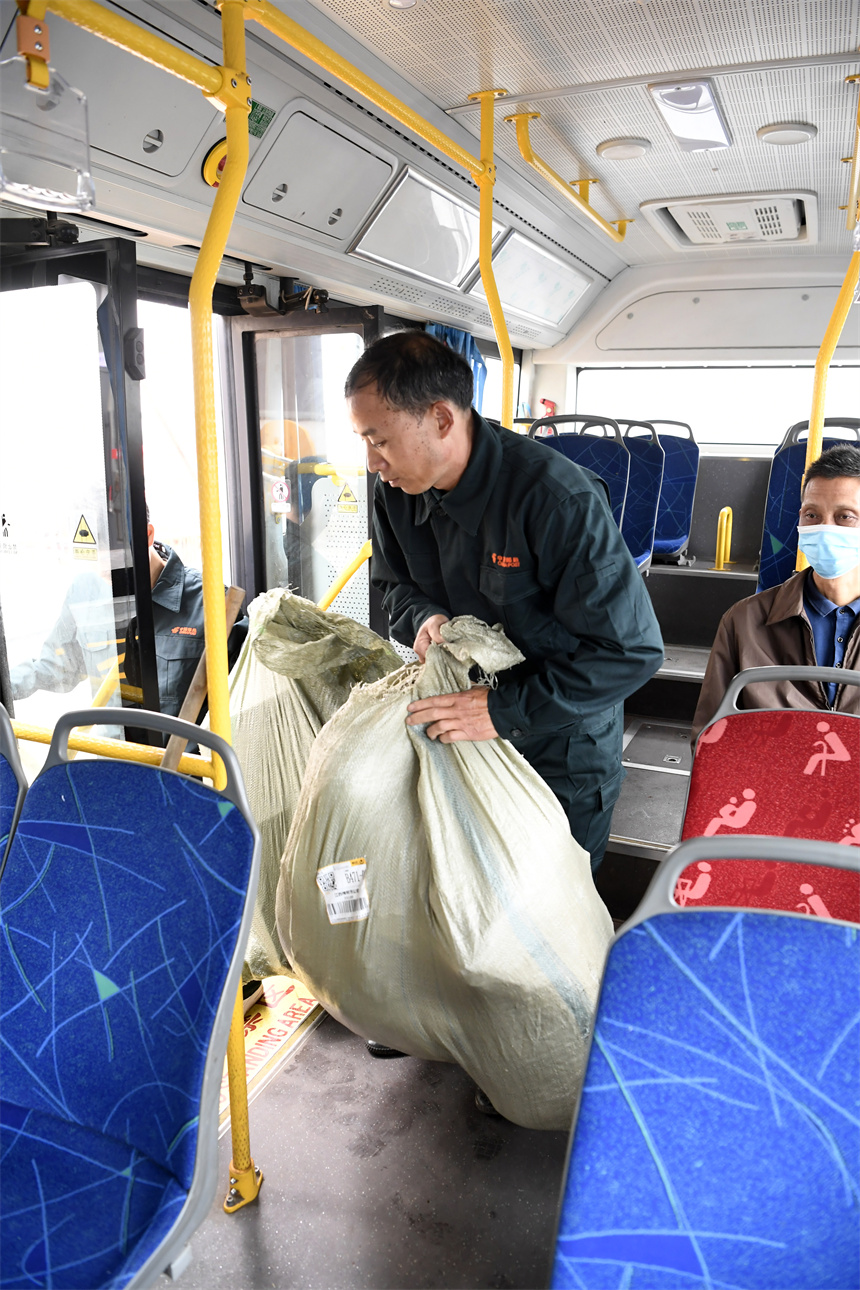 江西省樟樹市吳城鄉客貨郵綜合服務中心，快遞員將公交車上的快遞拿下車。周亮攝