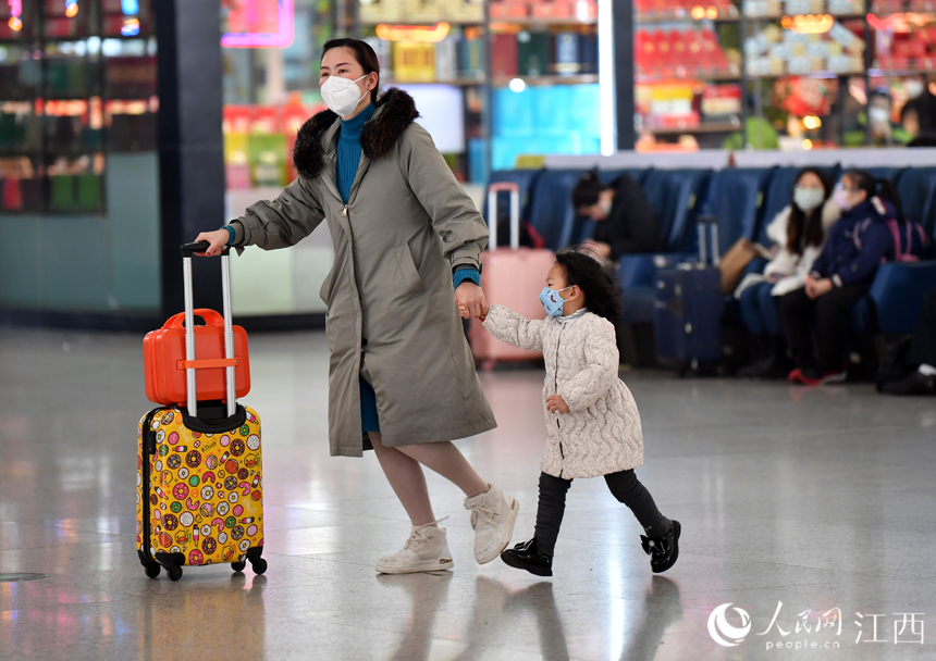 南昌西站，一名家長帶著孩子奔向檢票口。人民網 時雨攝