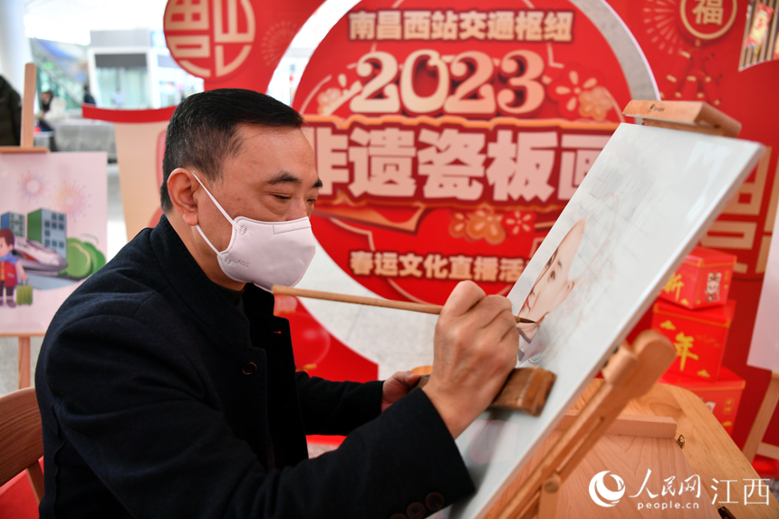 春運首日，一名非遺傳承人正在創作瓷板畫，向旅客展示非遺魅力。人民網 時雨攝