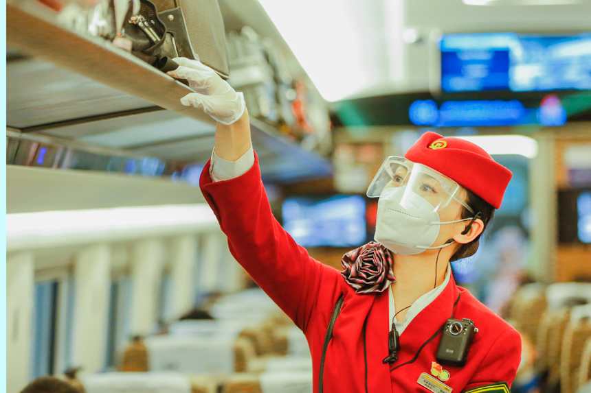 南昌客運段G894次乘務員正在整理行李架擺放物品。于永生攝