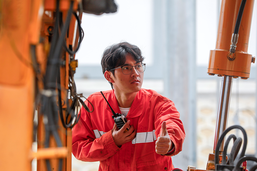 機械段職工指揮大型養路機械作業。高晉攝