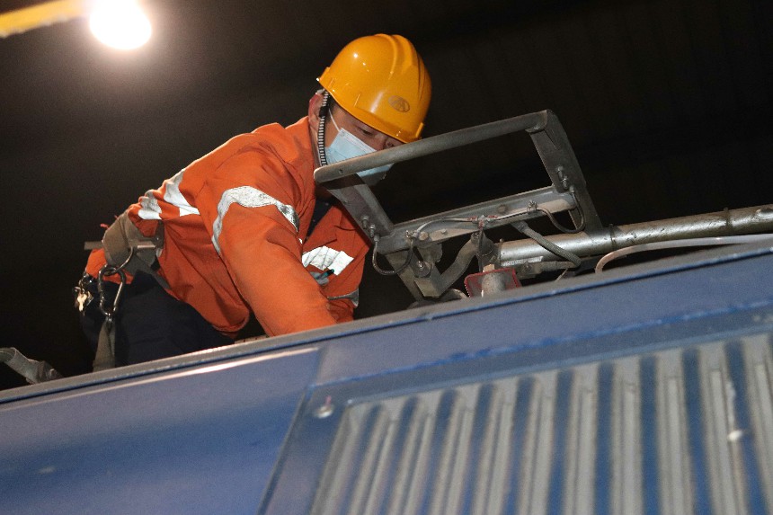 向塘機務段檢修工人正檢查電力機車車頂受電弓。吳木琴 攝