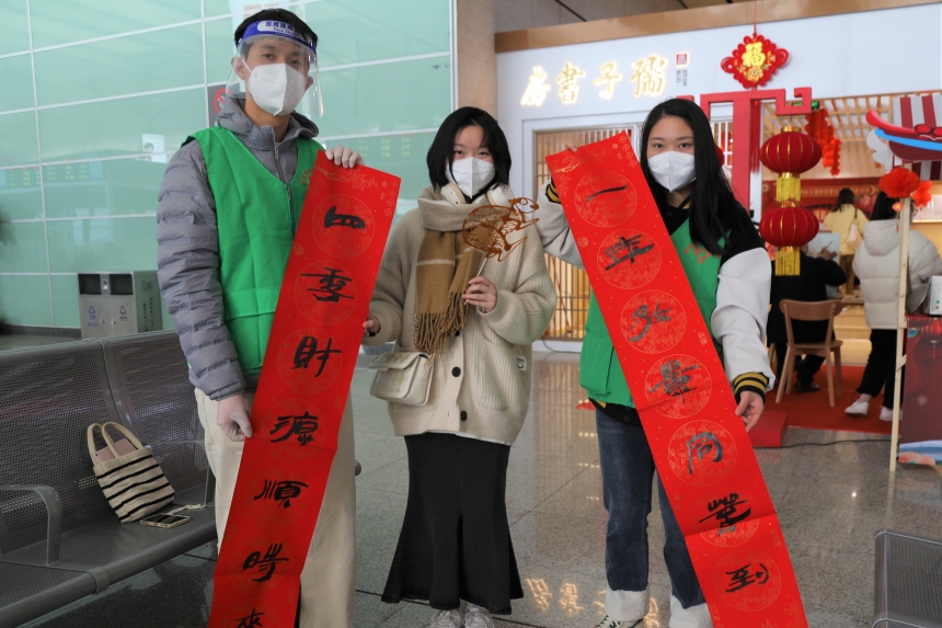 青年志愿者為旅客送上春聯。付映雪攝