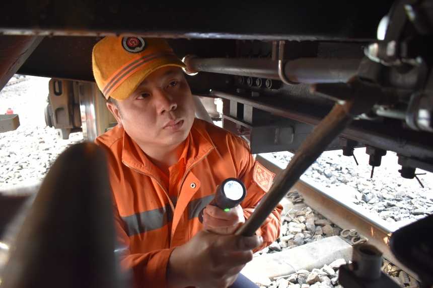 檢車員肖雪峰正在檢查列車風管作用狀態。付順明攝
