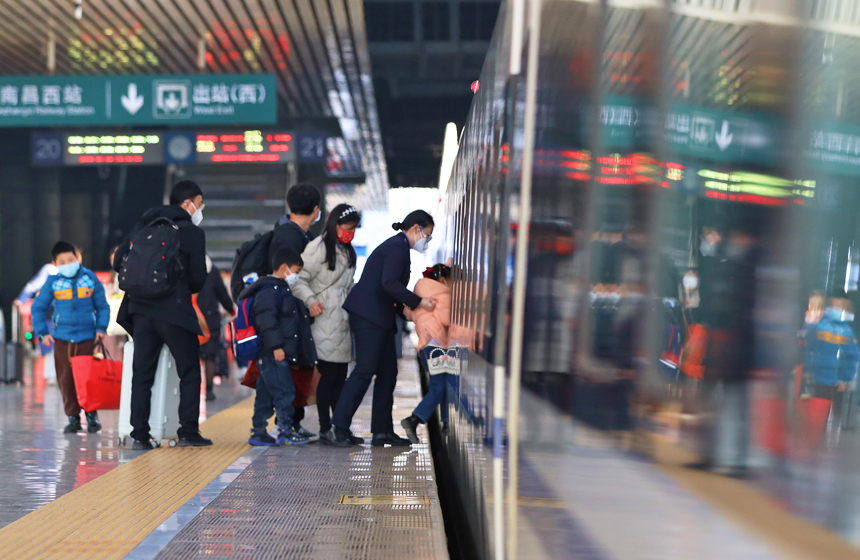 南昌客運段G1470次列車工作人員正在幫助小旅客登車。丁波攝