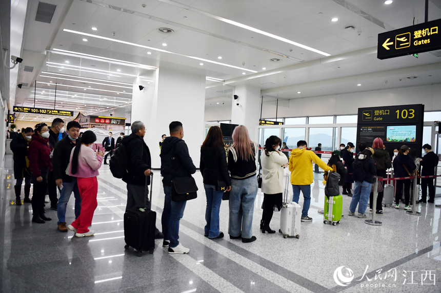 旅客通過登機口登機。人民網 時雨攝