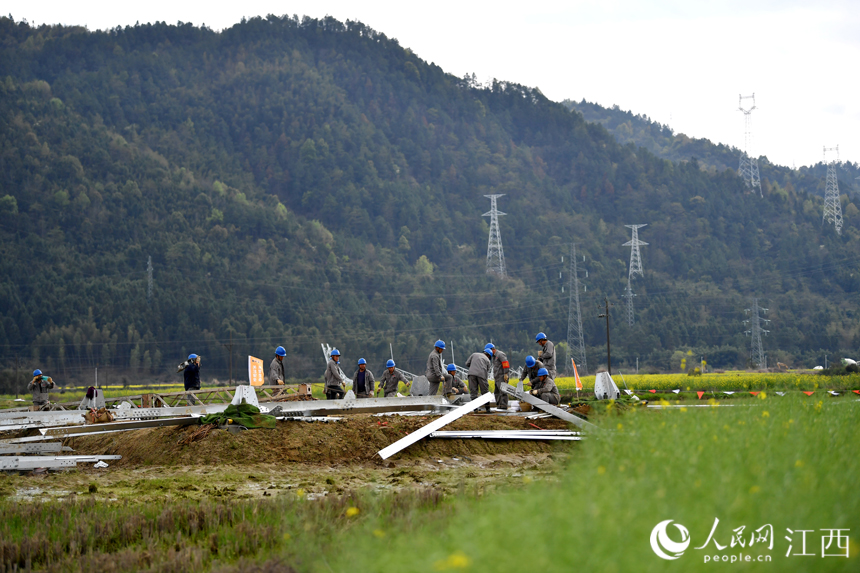 電網工作人員正在地面組裝電塔。人民網 時雨攝