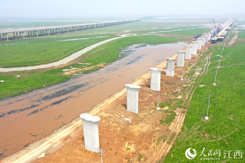 湖中已建成的高鐵橋墩與不遠處的快速路遙相呼應。 人民網 時雨攝