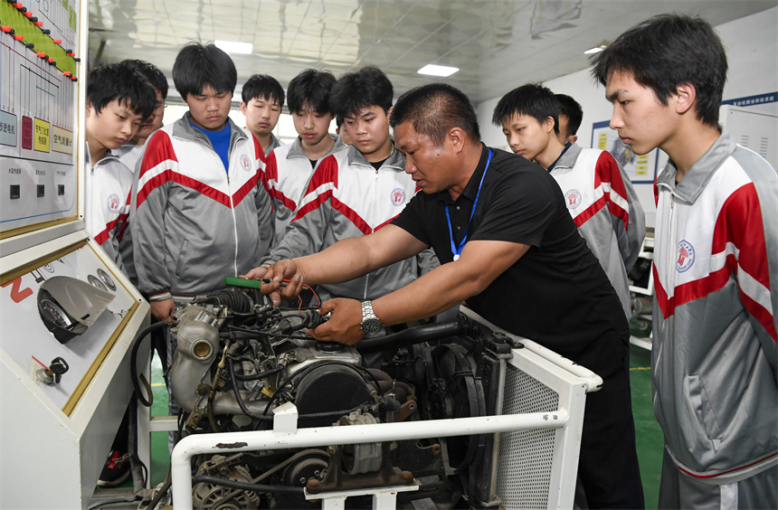 老師在向學生講解汽車的維修技巧。周亮攝