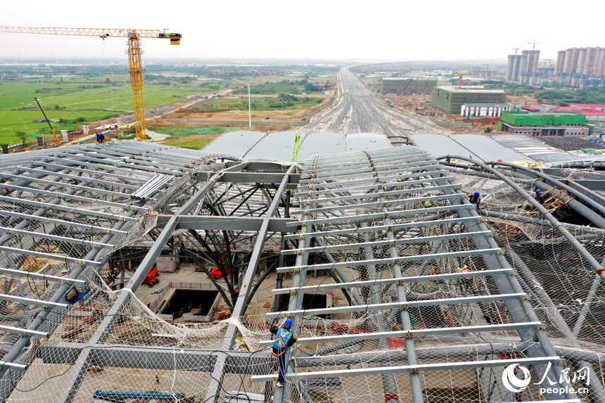 工人們正在南昌東站金屬屋面上方施工。 人民網記者 時雨攝