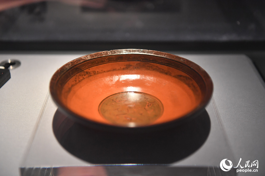 云獸紋漆盤是一種食器。唇部口沿處用朱漆繪有一圈卷云紋，內底繪有三條卷曲狀云獸紋。漆盤是漢代貴族生活不可或缺的日用品類，而云獸紋反映了漢代民眾對于仙界的想象及漢代神仙觀念的盛行。人民網記者 時雨攝