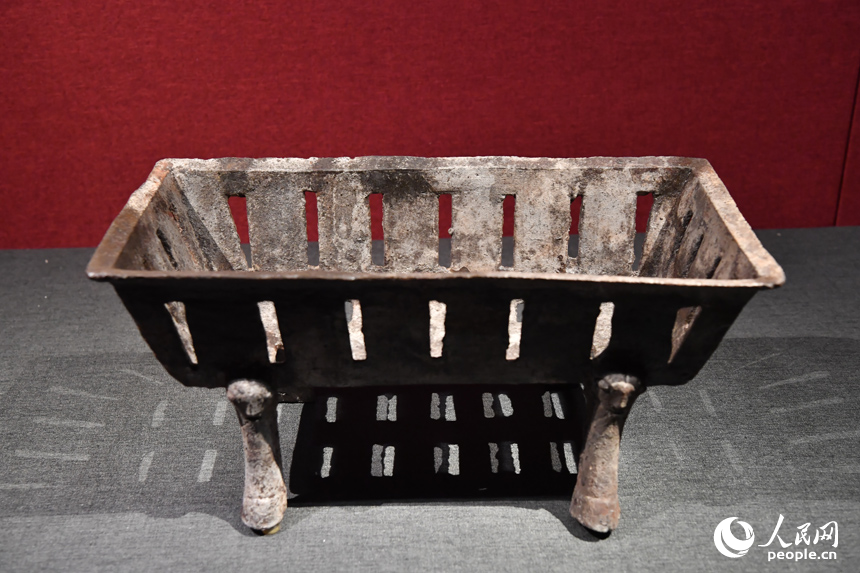 鏤空方形鐵爐是一種生活用具。該器呈長方形，器壁微斜向內收，器身有多處長方形鏤空，下承四足蹄?？赡苁侨∨镁呋蛑丝敬毒?。人民網記者 時雨攝