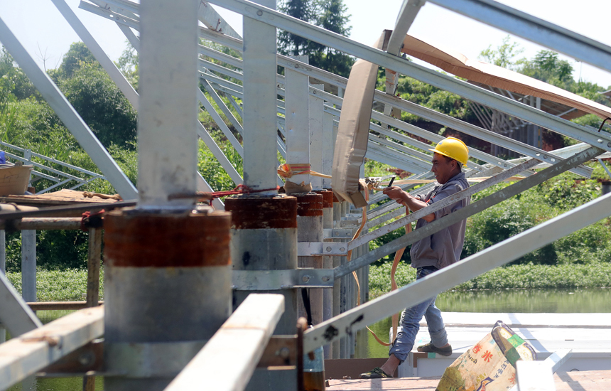 施工人員在光伏電板安裝現場忙碌。何賤來攝