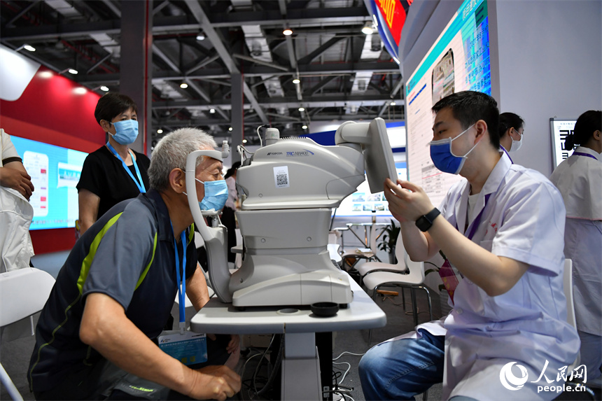 展會現場，醫護人員正利用智慧醫療儀器為觀眾現場診療。 人民網記者 時雨攝