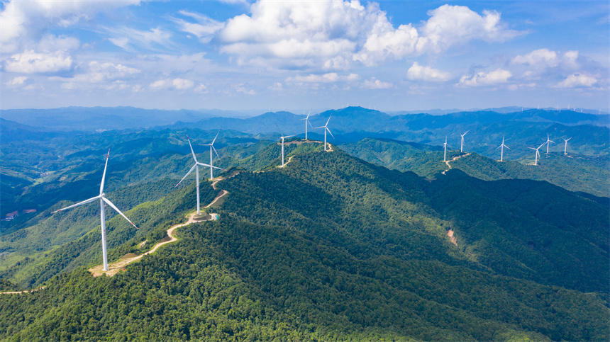 一臺臺風力發電機矗立在群山之巔，美不勝收。李凡欽攝