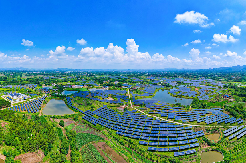 一排排光伏發電板與農居、田園相映成趣，呈現一派鄉村振興的美景。楊鑫攝