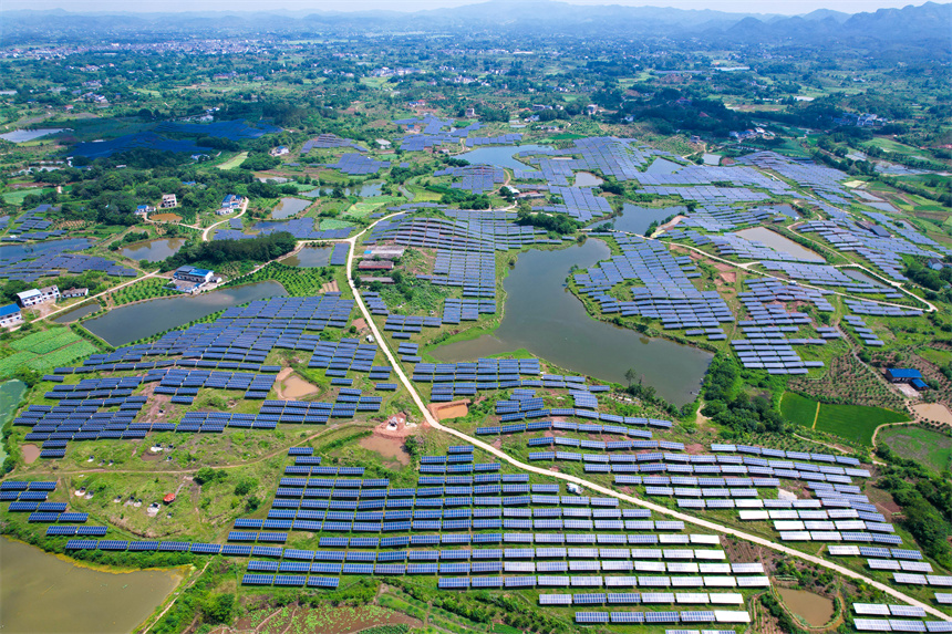 一排排光伏發電板與農居、田園相映成趣，呈現一派鄉村振興的美景。楊鑫攝