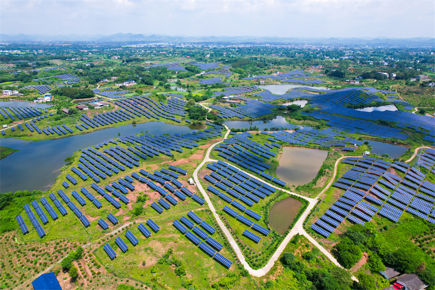 一排排光伏發電板與農居、田園相映成趣，呈現一派鄉村振興的美景。楊鑫攝