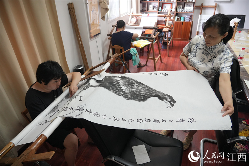 顧玉純的徒弟和他正在創作的宣紙刺繡作品。人民網 孔文進攝