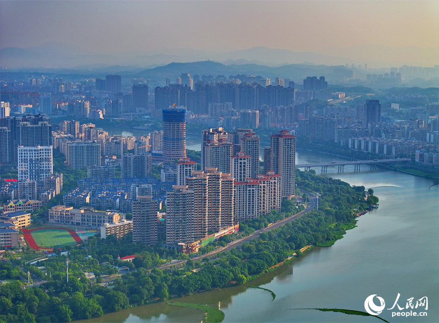 航拍下的江西省贛州章江國家濕地公園河道蜿蜒，江岸綠樹環繞。人民網朱海鵬攝