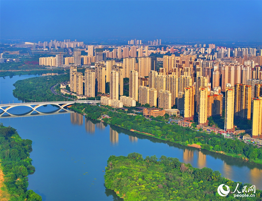 航拍下的江西省贛州章江國家濕地公園河道蜿蜒，江岸綠樹環繞。人民網朱海鵬攝
