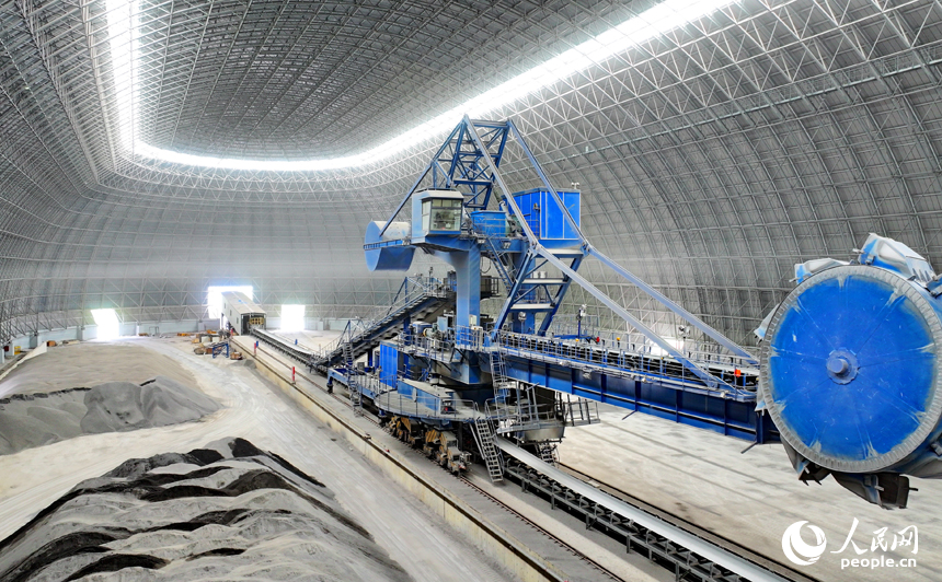 九江市柴桑區的九江港赤湖作業區公用碼頭全封閉智慧“膠囊”倉庫內，大型機械設備在進行取料作業。人民網 朱海鵬攝