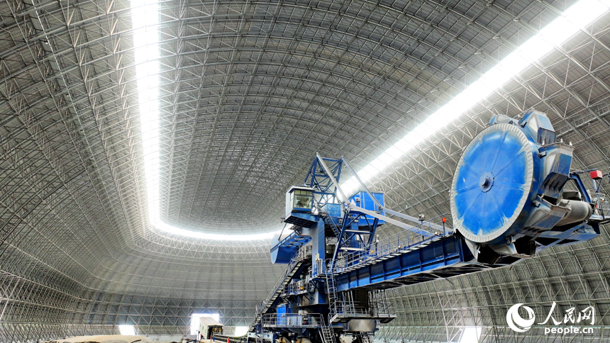 九江市柴桑區的九江港赤湖作業區公用碼頭全封閉智慧“膠囊”倉庫內，大型機械設備在進行取料作業。人民網 朱海鵬攝