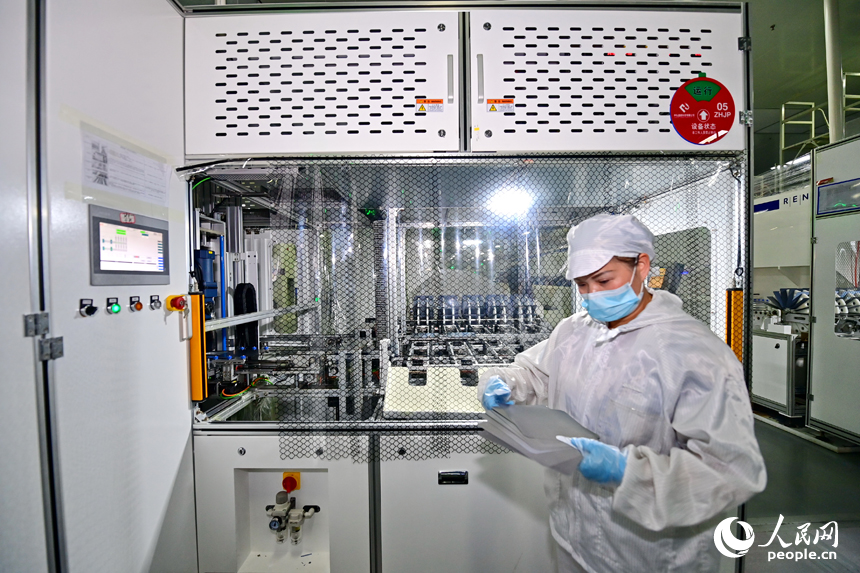 撫州市宜黃縣六里鋪工業園區的光伏組件生產企業，工人在生產線上查看電池片工藝。人民網 朱海鵬攝