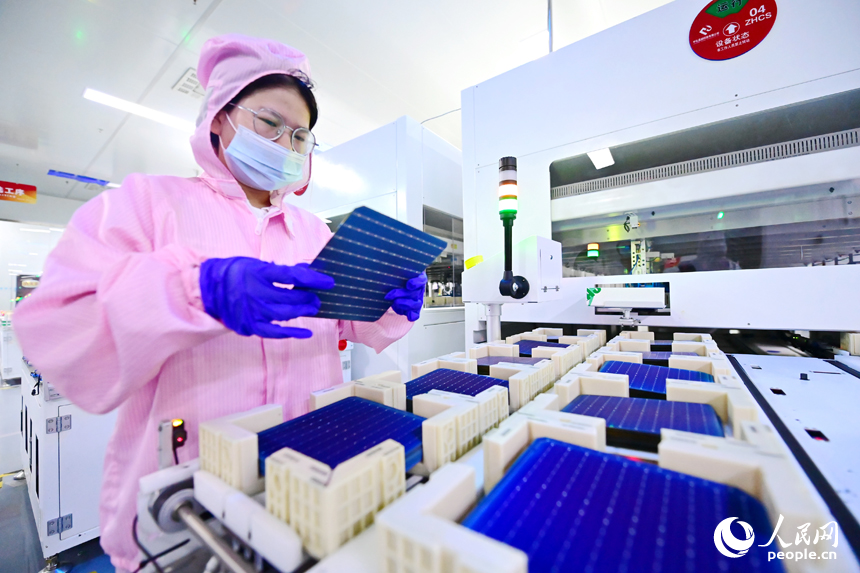 撫州市宜黃縣六里鋪工業園區的光伏組件生產企業，工人在生產線上查看電池片工藝。人民網 朱海鵬攝
