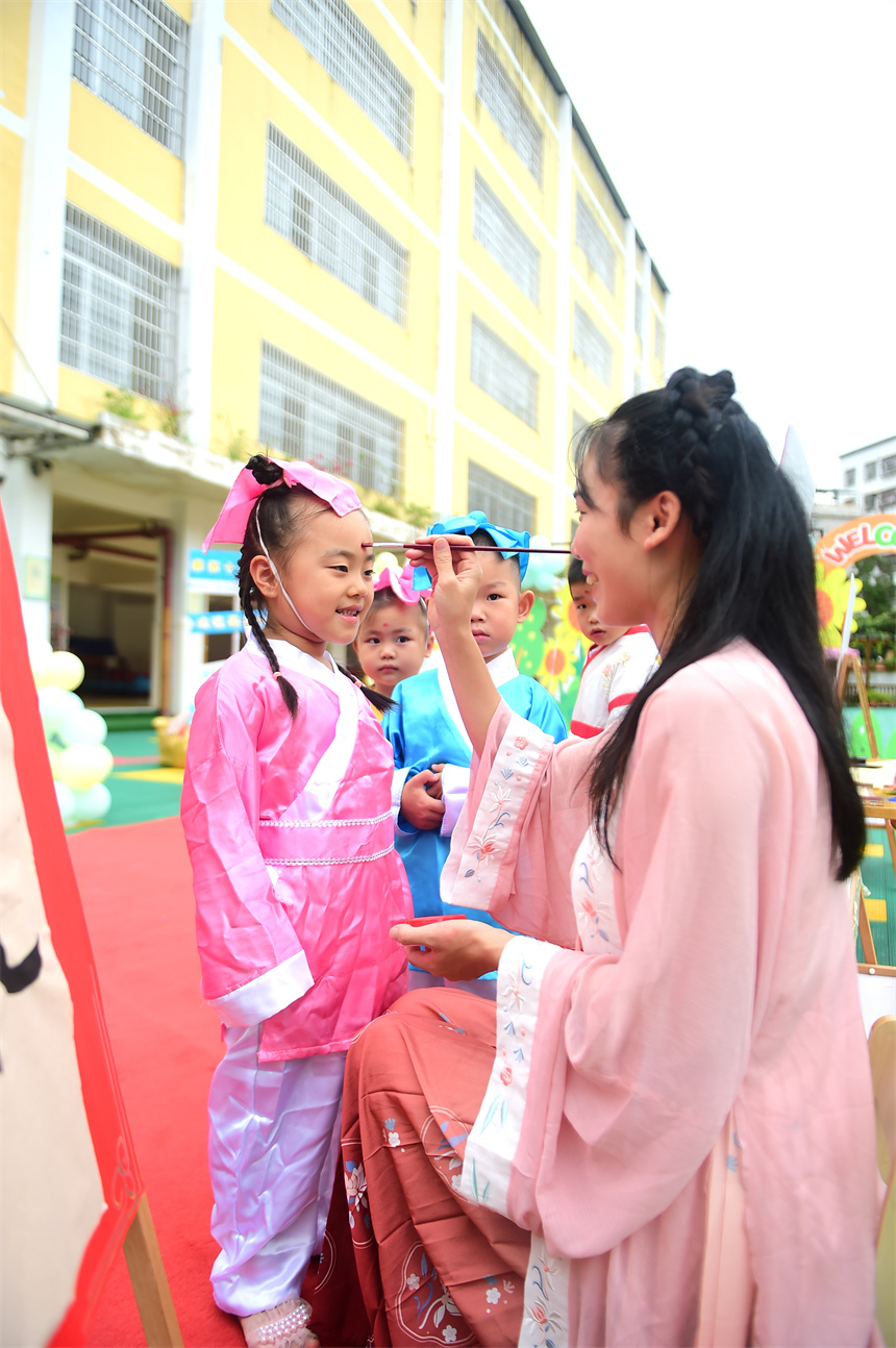 老師給小朋友點朱砂痣。呂春華攝