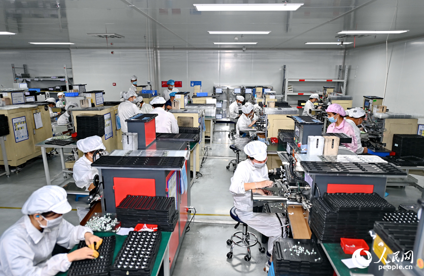 近日，鋰電新能源電池生產企業內，工人在操作電子設備趕制電池產品訂單。人民網 朱海鵬攝