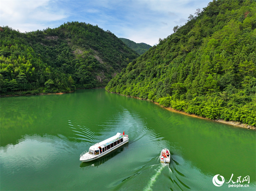 近日，江西省贛州市安遠縣三百山東風湖，生態保潔員駕駛保潔船在清理水面漂浮物。人民網 朱海鵬攝