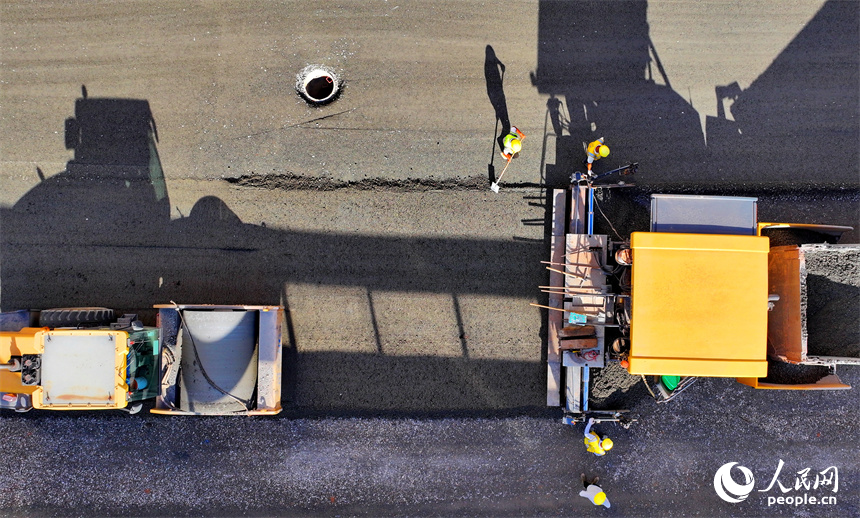 近日，江西省贛州市蓉江三路快速路建設點，工人在攤鋪混凝土，加快推進橋梁附屬道路建設。人民網 朱海鵬攝