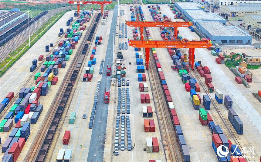 大型吊裝設備在裝運出口的國產電動載人汽車。人民網 朱海鵬攝