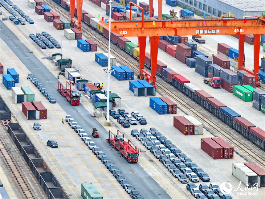 大型吊裝設備在裝運出口的國產電動載人汽車。人民網 朱海鵬攝