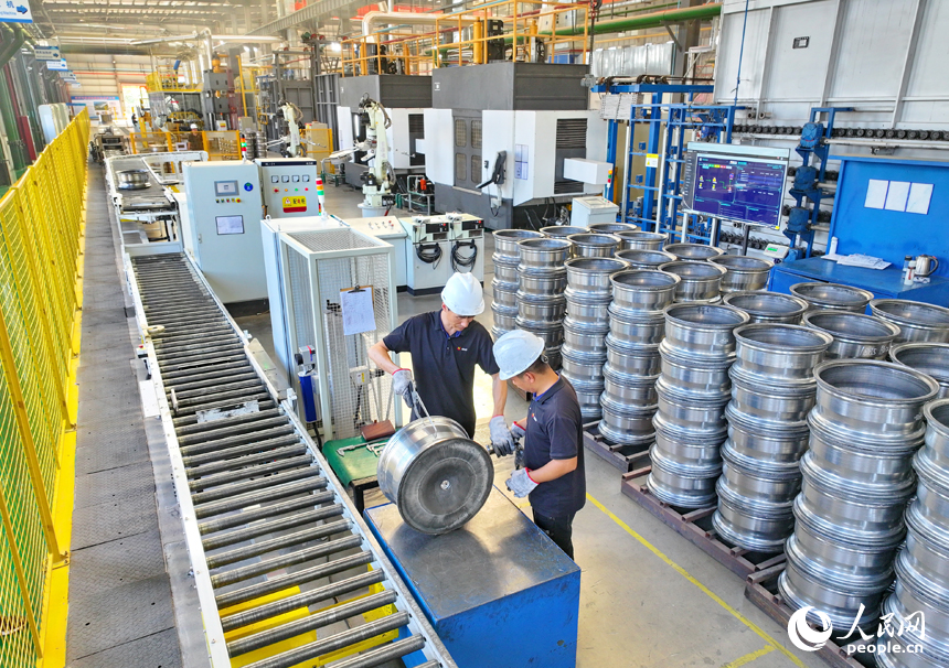 車間內，工人在操作新型智能設備趕制出口輪轂訂單產品。人民網 朱海鵬攝