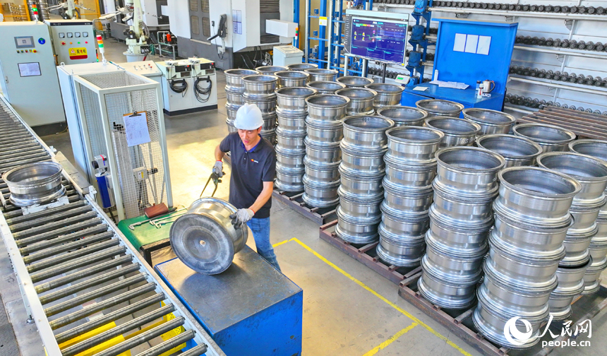 車間內，工人在操作新型智能設備趕制出口輪轂訂單產品。人民網 朱海鵬攝