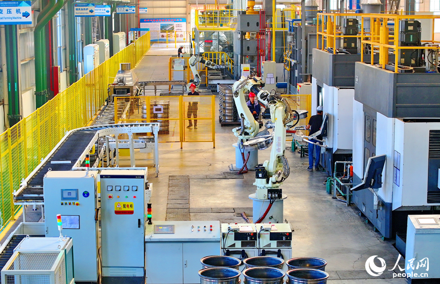 車間內，工人在操作新型智能設備趕制出口輪轂訂單產品。人民網 朱海鵬攝