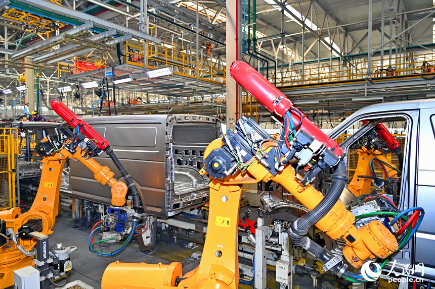 機械手臂在快速運轉，進行微型快遞運輸車車廂自動化焊接。人民網 朱海鵬攝