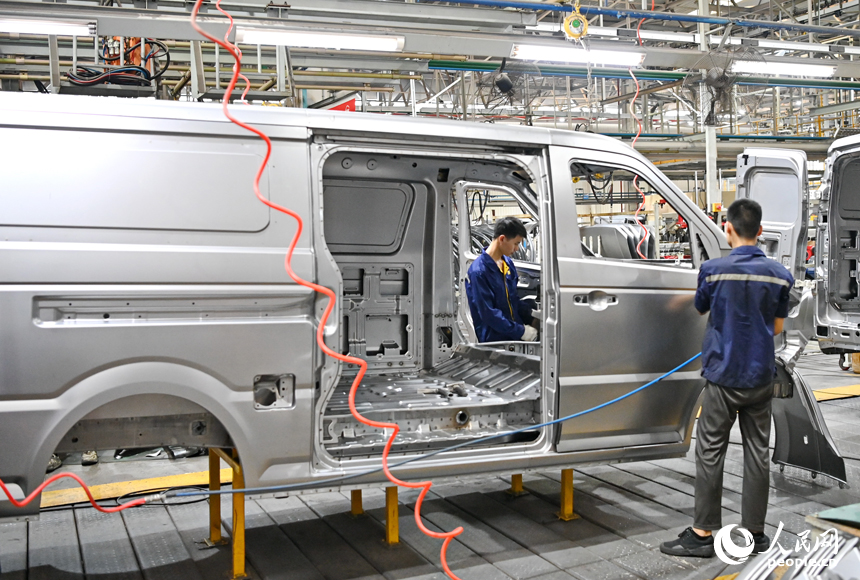 工人在給微型快遞運輸車車廂封膠。人民網 朱海鵬攝