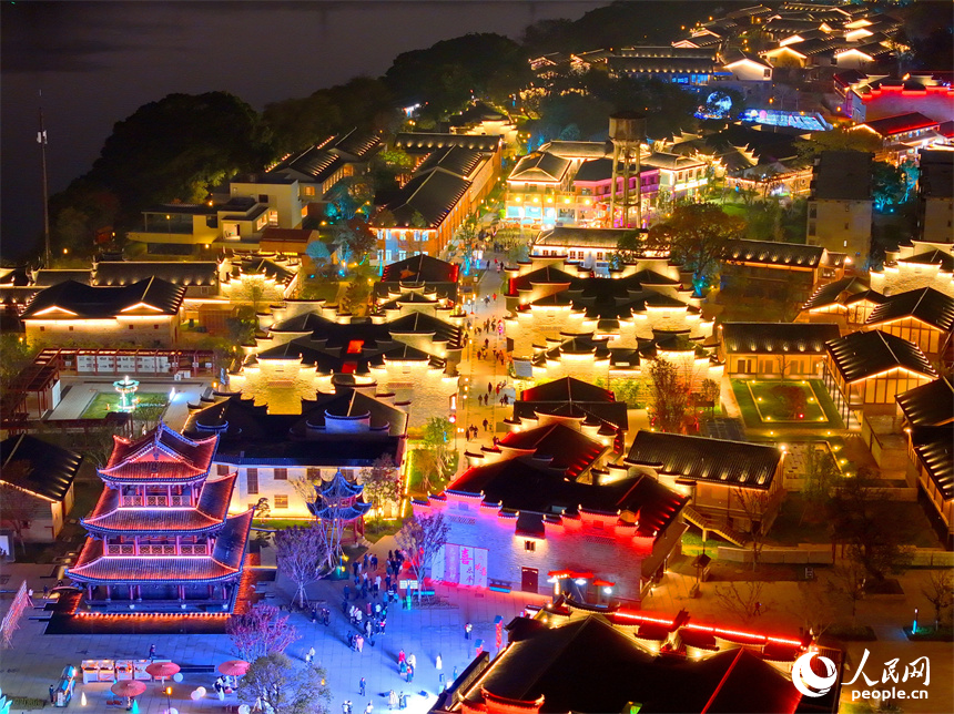 夜色中的七鯉古鎮，與遠處城市高樓大廈相輝映，古色古韻與現代氣息的交融，吸引了許多游客。人民網 朱海鵬攝