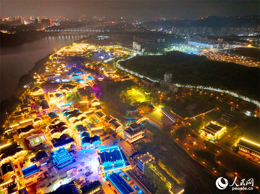 夜色中的七鯉古鎮，與遠處城市高樓大廈相輝映，古色古韻與現代氣息的交融，吸引了許多游客。人民網 朱海鵬攝