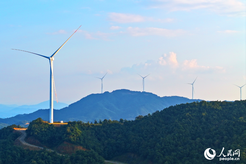 贛州市定南縣歷市鎮群山之上，風力發電機迎風旋轉，轉化為清潔電源并入電網輸往工廠企業、千家萬戶。人民網 朱海鵬攝