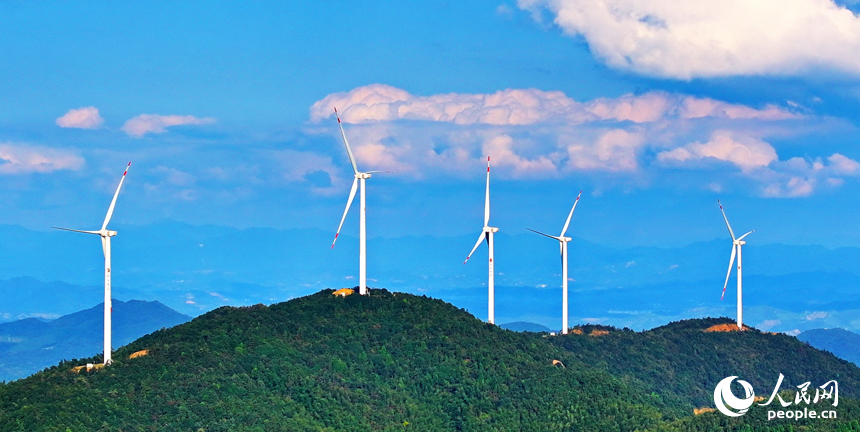 贛州市定南縣歷市鎮群山之上，風力發電機迎風旋轉，轉化為清潔電源并入電網輸往工廠企業、千家萬戶。人民網 朱海鵬攝