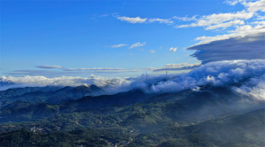 一臺臺風力發電機矗立在群山之巔，蔚為壯觀。詹繼成攝